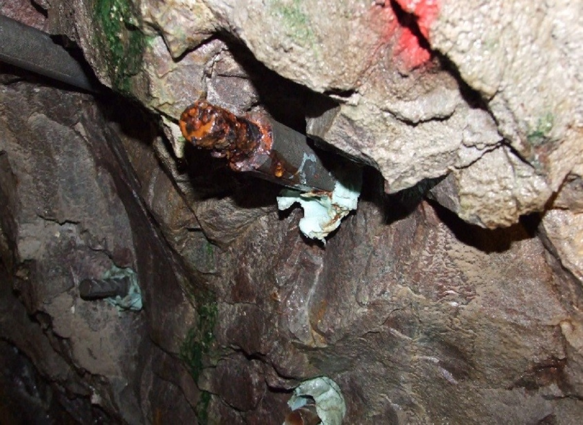 Högt pH-värde på vattnet i tunnlar ger korrosionsskydd på bultar. Bilden visar en delvis utdragen exponerad kolstålsbult efter åtta års provning och korrosionsprovningsplats i Äspötunneln, i Oscarshamns kommun.